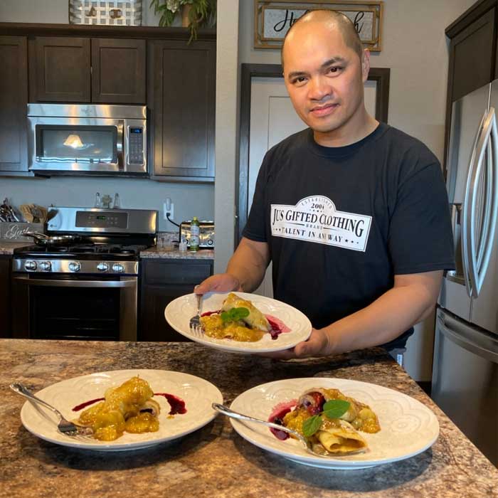 man making food while wearing Jus Gifted shirt
