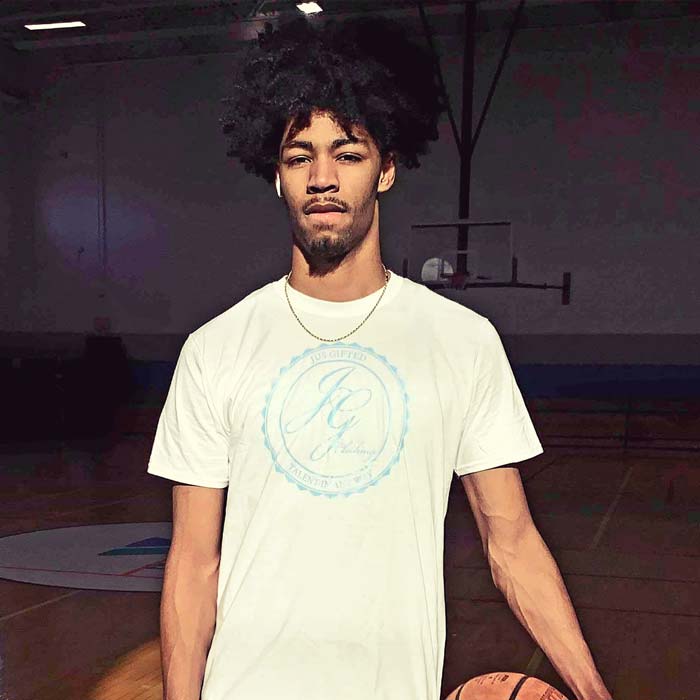 man in gym holding basketball and wearing Jus Gifted shirt